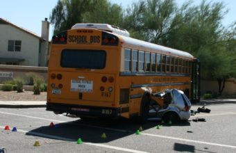 Car crushed by school bus, example of turing accident
